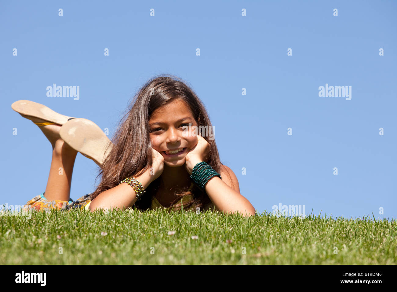 Un giovane bambino posa sull'erba in un giorno di estate Foto Stock