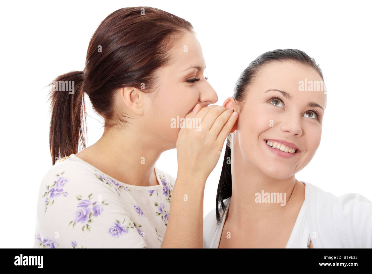 Due giovani felici fidanzate parlando su bianco Foto Stock