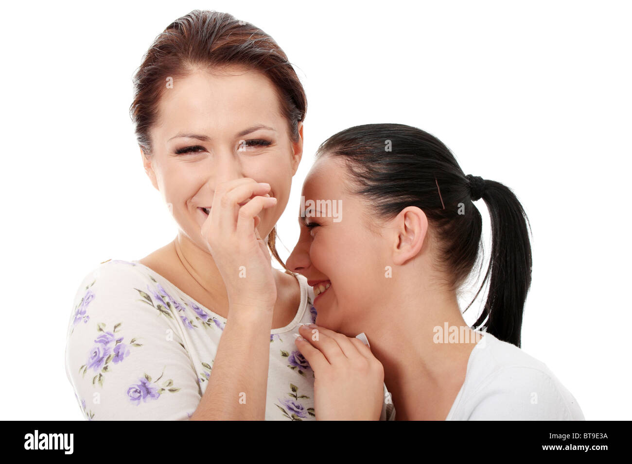 Due giovani felici fidanzate parlando su bianco Foto Stock