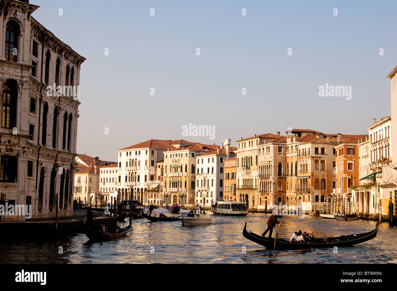 In serata calda sunshine una gondola attraversa il Canal, Venezia Italia. Preso dal Ponte di Rialto Foto Stock