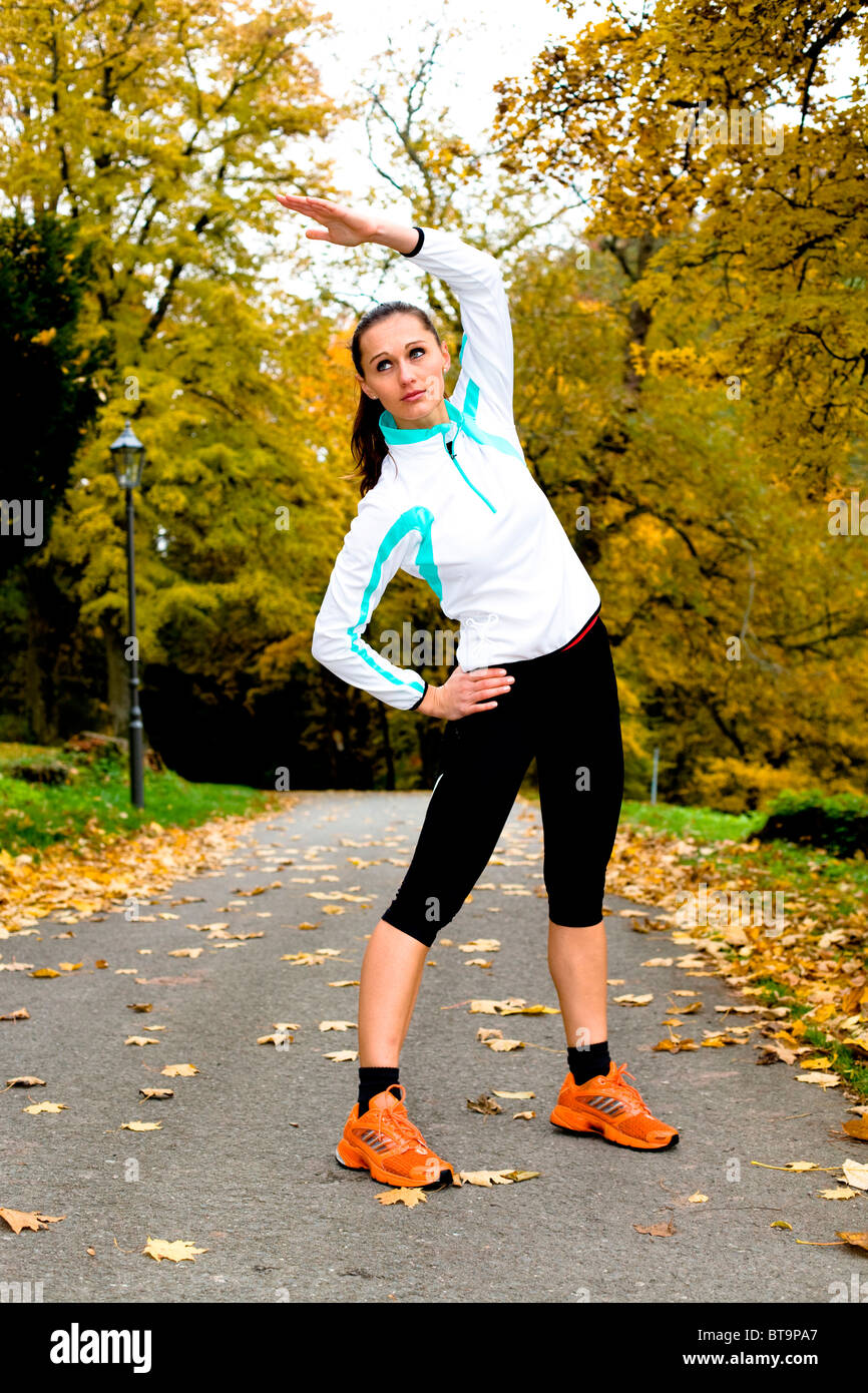 Giovane donna in fase di riscaldamento prima di fare jogging Foto Stock