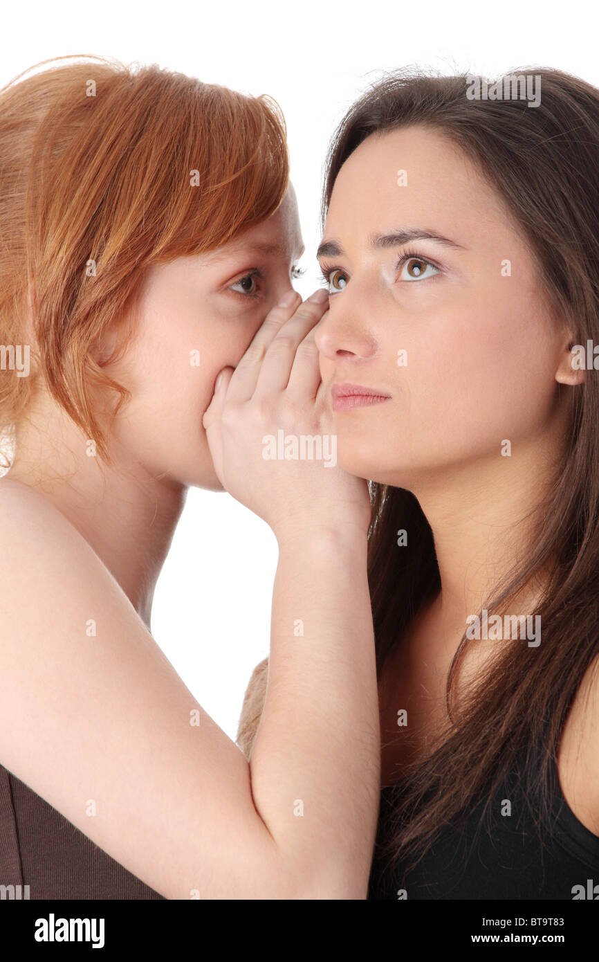 Due giovani womans parlando gossip isolati su sfondo bianco Foto Stock