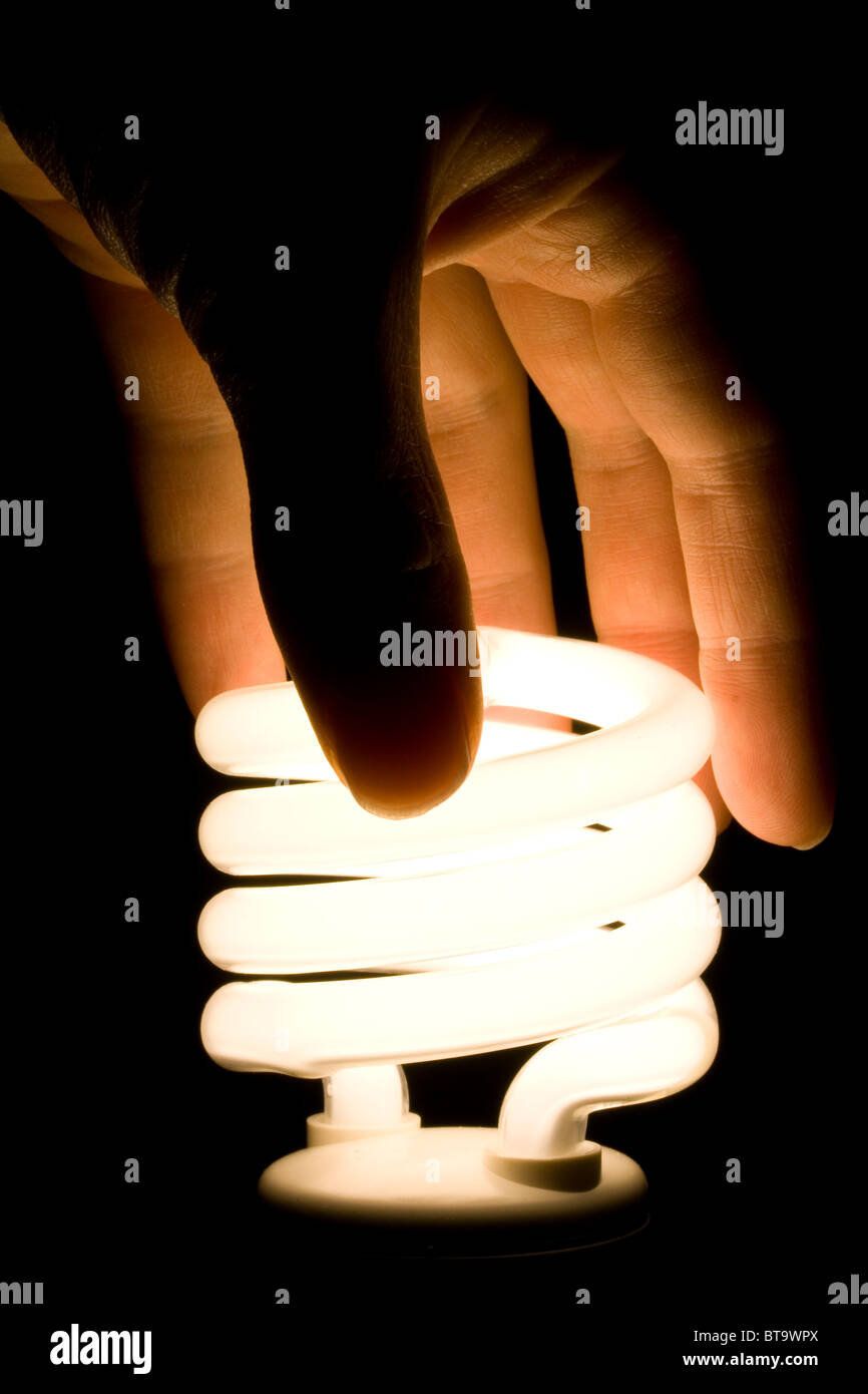 Mano Installazione efficiente di energia fluorescente lampadina della luce Foto Stock