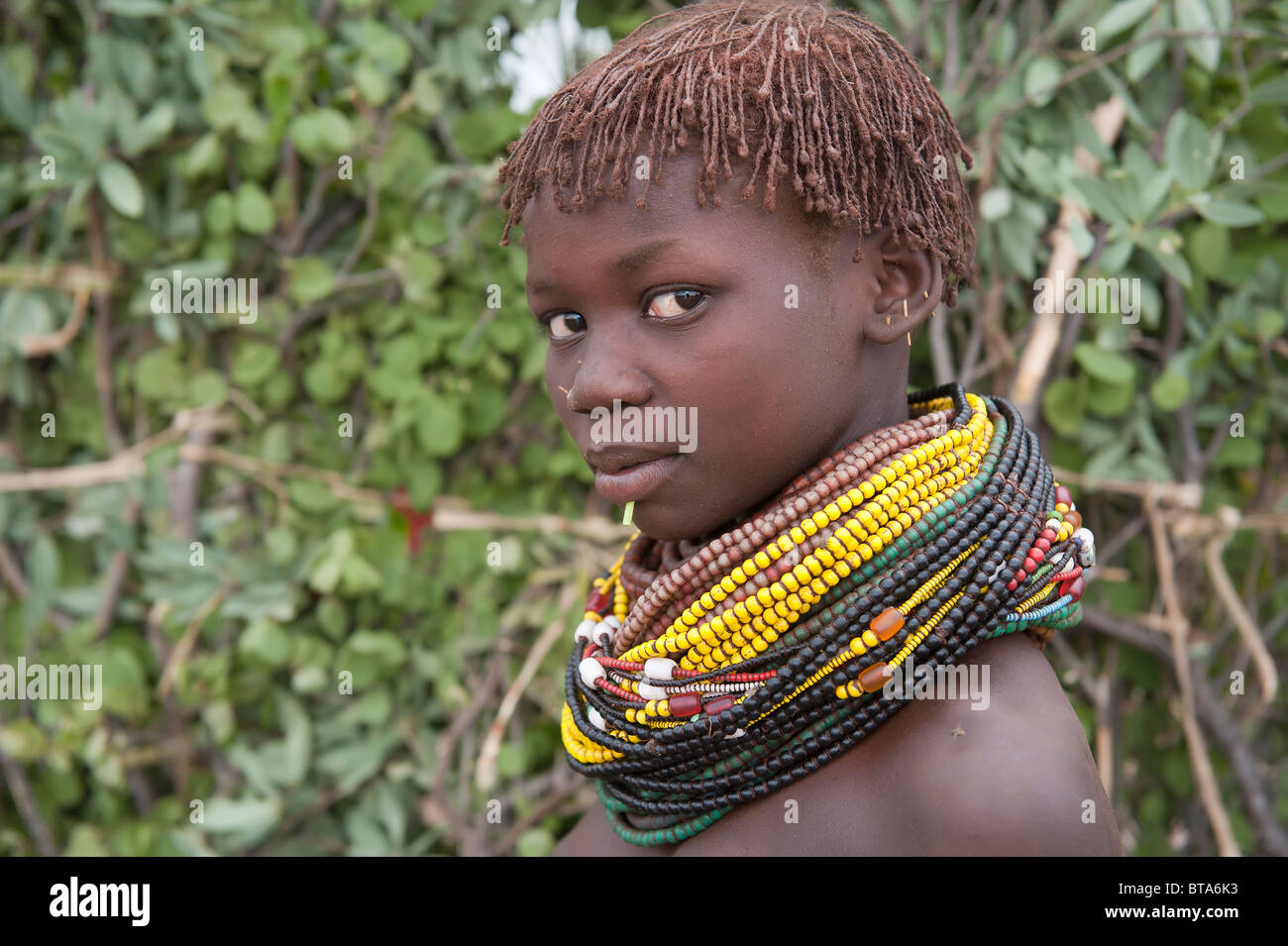 Nyangatom (Bumi) ragazza con pile di perle, Omo river Valley, Etiopia Foto Stock
