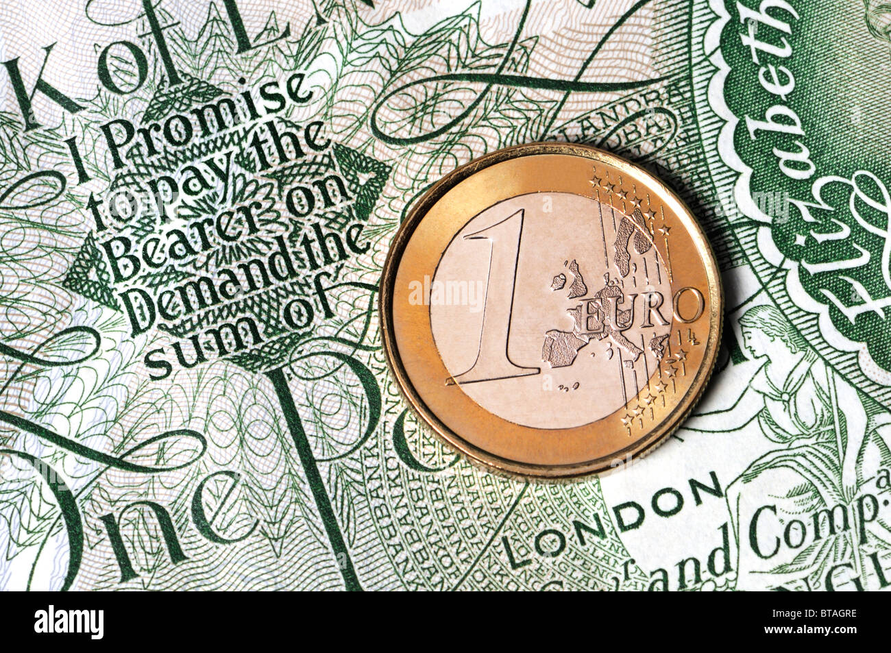Un Euro moneta sul vecchio British Pound nota 'prometto di pagare il portatore della domanda la somma di.... 1 Euro" Foto Stock
