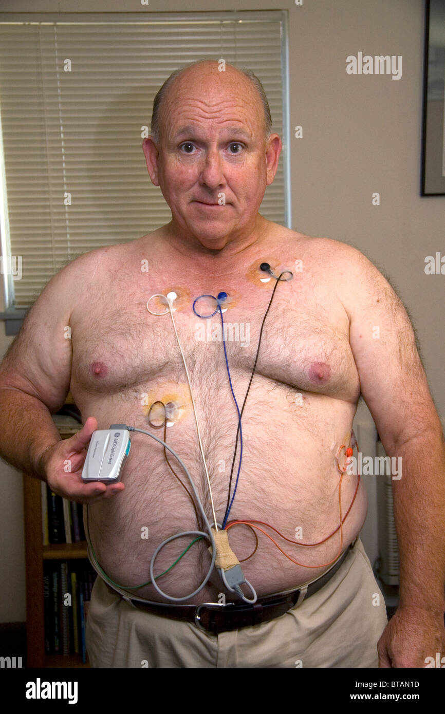 American uomo che indossa un monitor Holter utilizzato per il monitoraggio di cuore per le aritmie cardiache. Signor Foto Stock