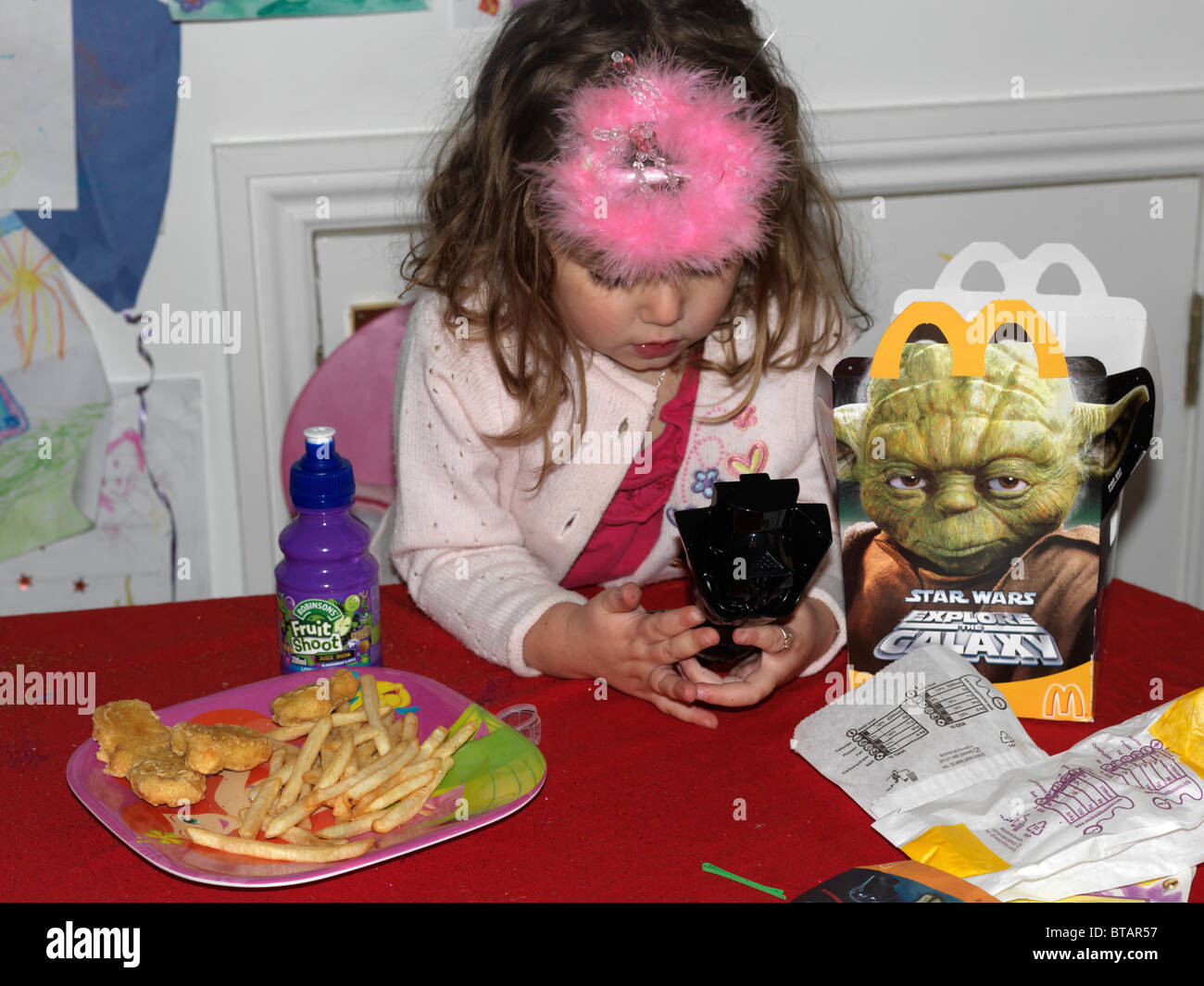 Ragazza giovane con un Mcdonald's Happy Meal giocando con una Star Wars toy Inghilterra Foto Stock