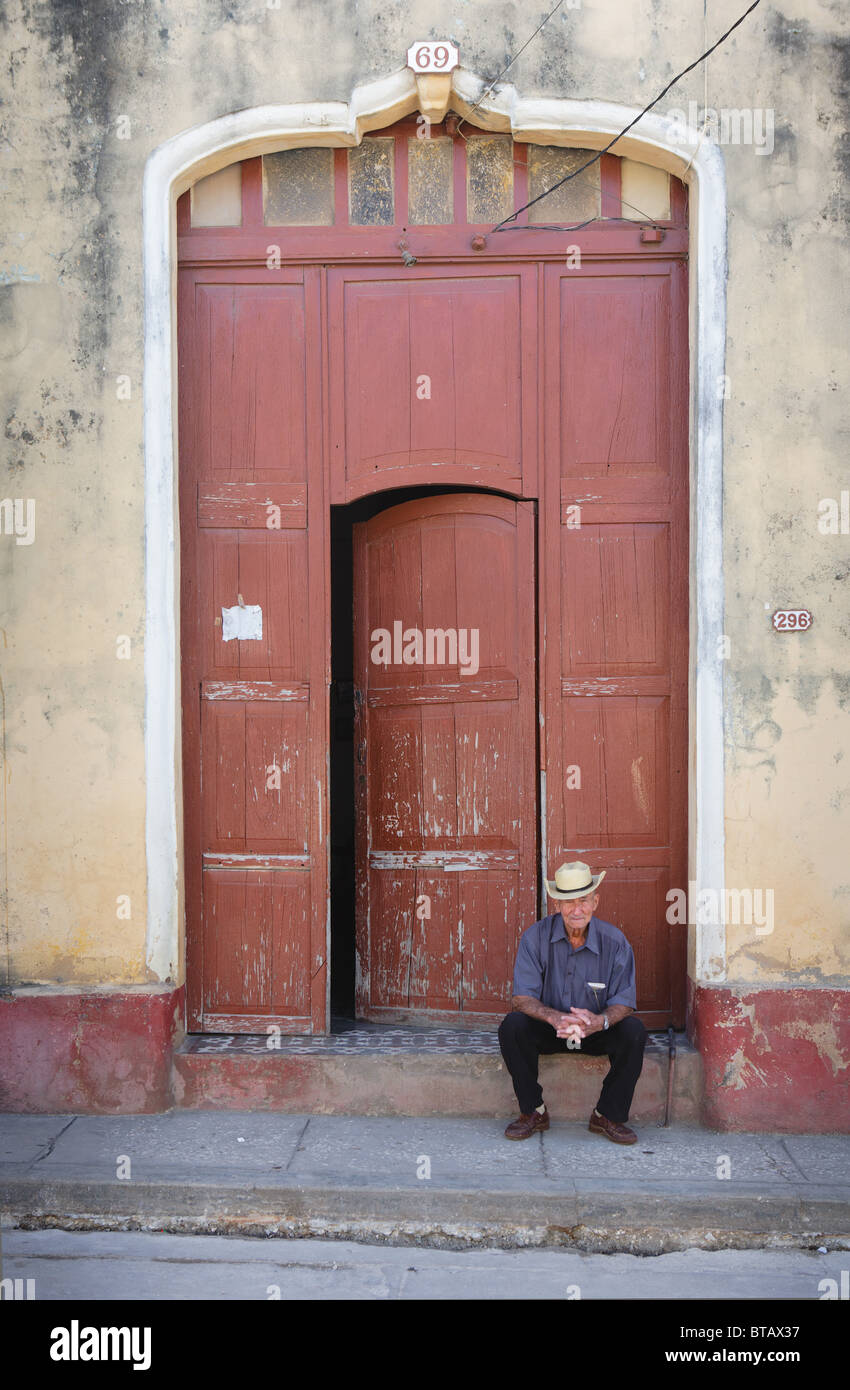 TRINIDAD: uomo cubano seduto in porta Foto Stock