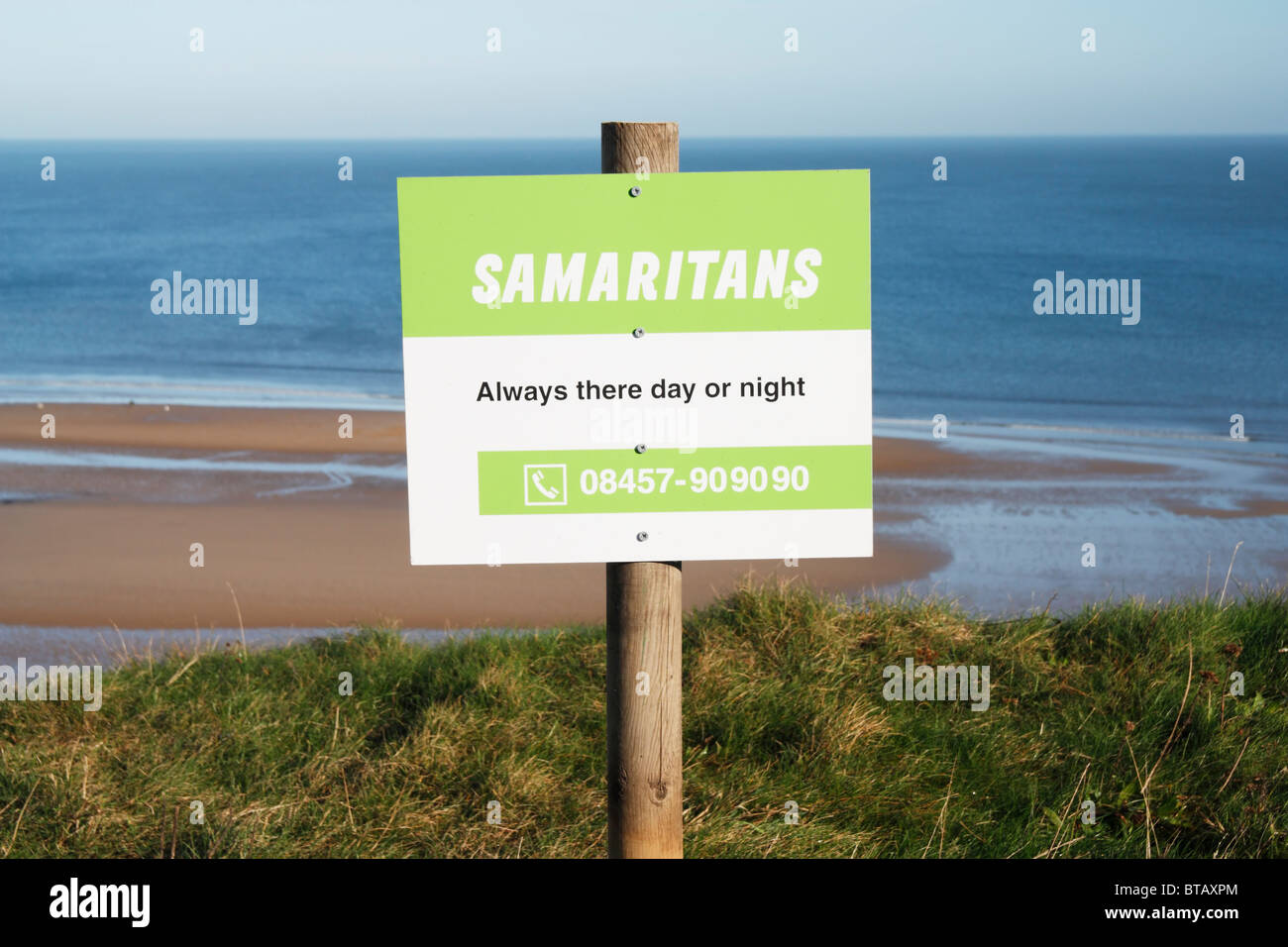 Samaritns segno con il numero di telefono sulla scogliera il bordo sul modo di Cleveland sentiero costiero Foto Stock