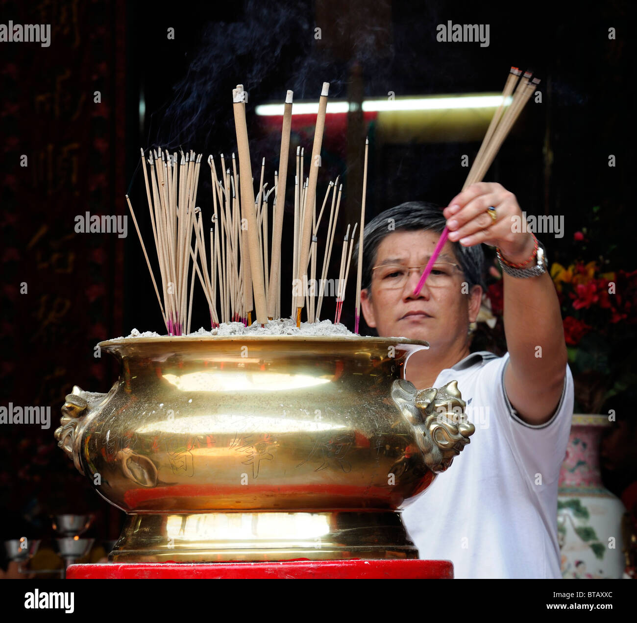 Peccato Sze Si Ya Cinese Tempio Taoista Chinatown Kuala Lumpur in Malesia uomo bruciando incenso cinese tradizionale culto divinità Foto Stock