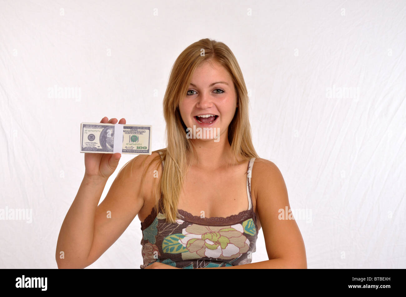 La donna sorpresa in possesso di una pila di denaro Foto Stock