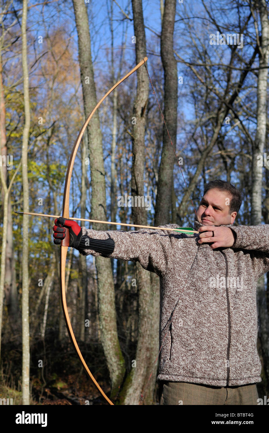 L'uomo tiro con arco e frecce nella foresta, Stockholms Lan, Svezia Foto  stock - Alamy