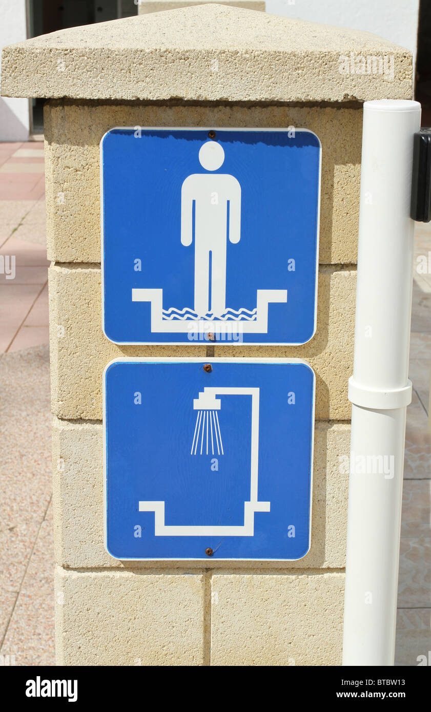 Piscina informazioni consulenza segni nuotatori a piedi attraverso un piede bagno doccia prima di utilizzare la piscina. Foto Stock
