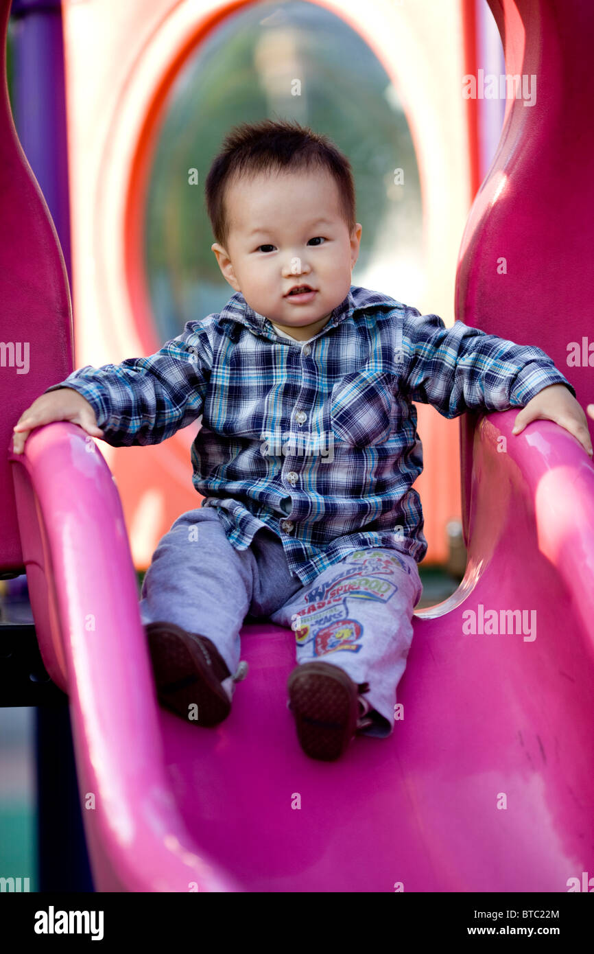 Un Cinese asiatici baby figlio giocando in un parco giochi per bambini Foto Stock