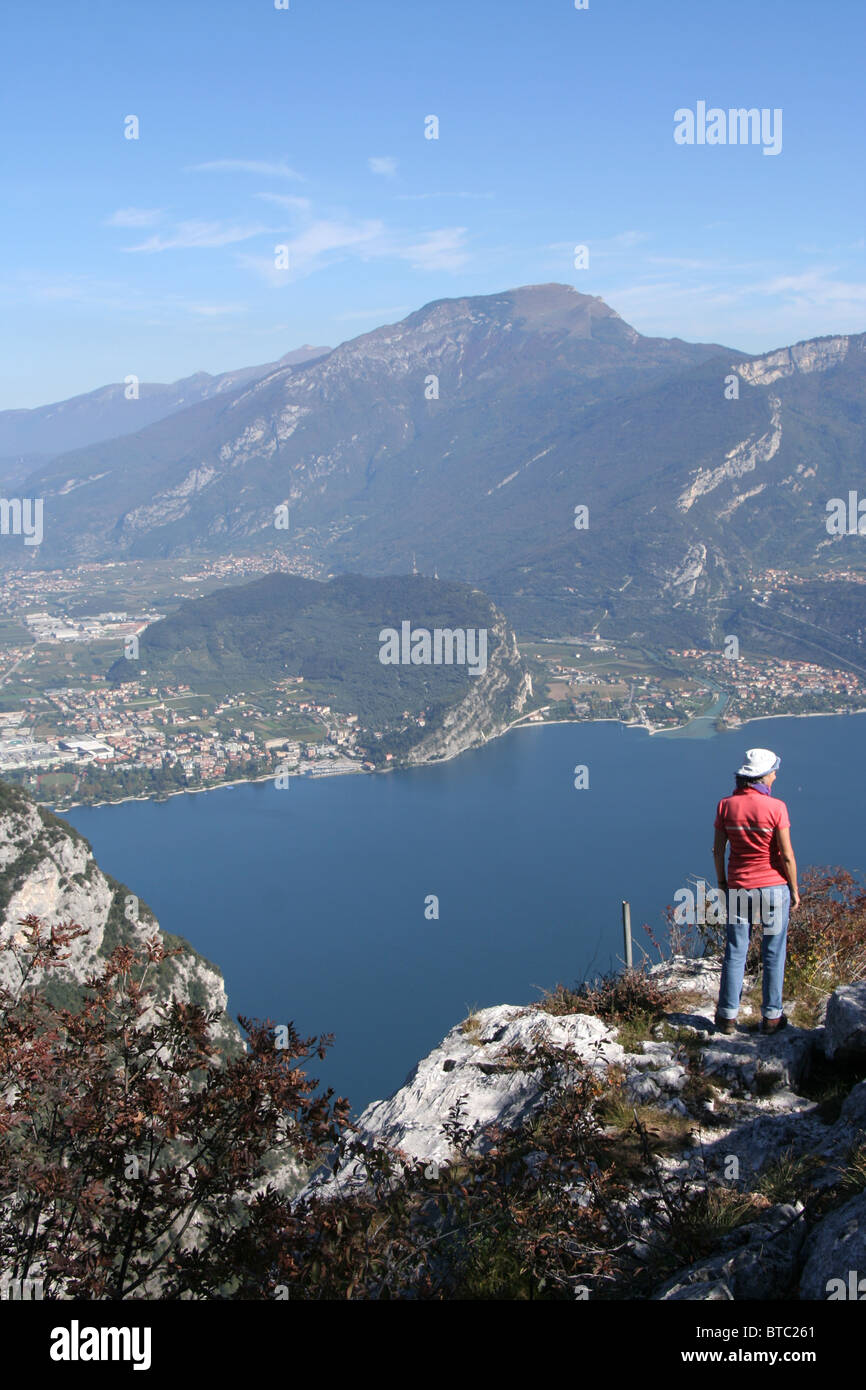 Donna sulla montagna che si affaccia a nord del Lago di Garda, Italia con viste per il Monte Brione e Torbole Foto Stock