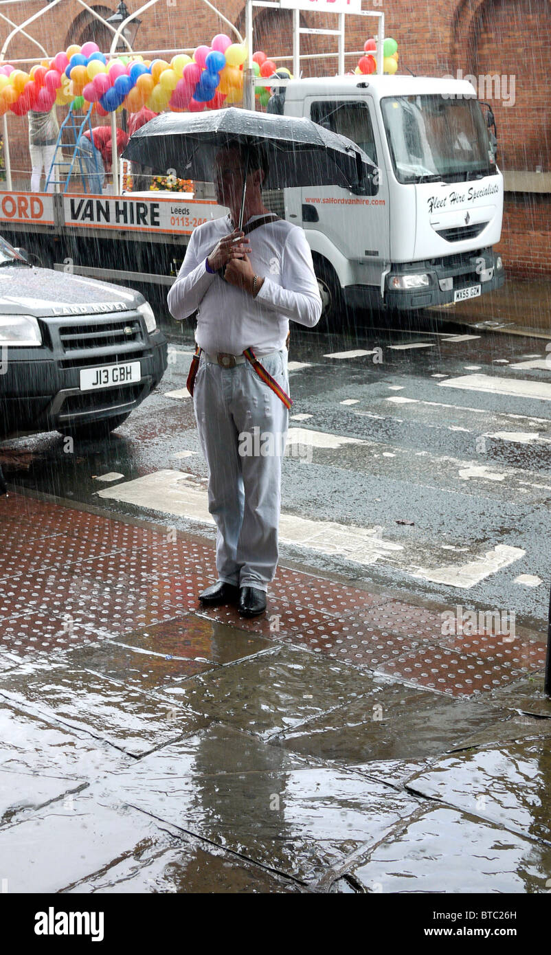 Gay uomo in piedi sotto la pioggia prima di Manchester Pride Parade 2010 REGNO UNITO Foto Stock