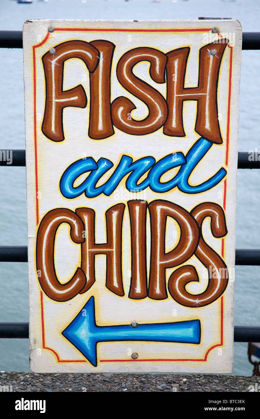 Pesci dai colori vivaci e segno di chip per un pesce e chip shop NEL REGNO UNITO Foto Stock
