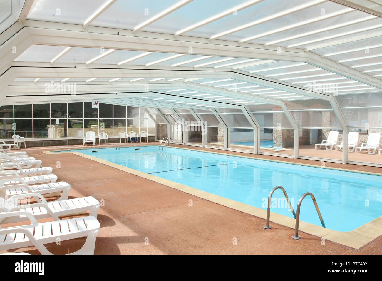 Piscina interna Piscina sotto la copertura di un tetto apribile a scomparsa Foto Stock