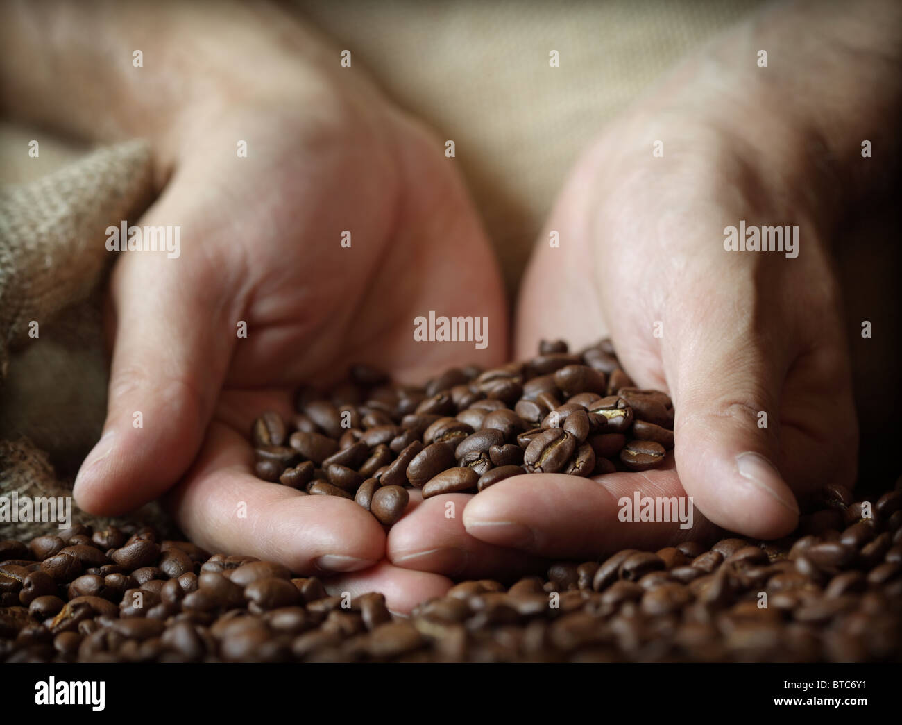 Mano che tiene i chicchi di caffè Foto Stock