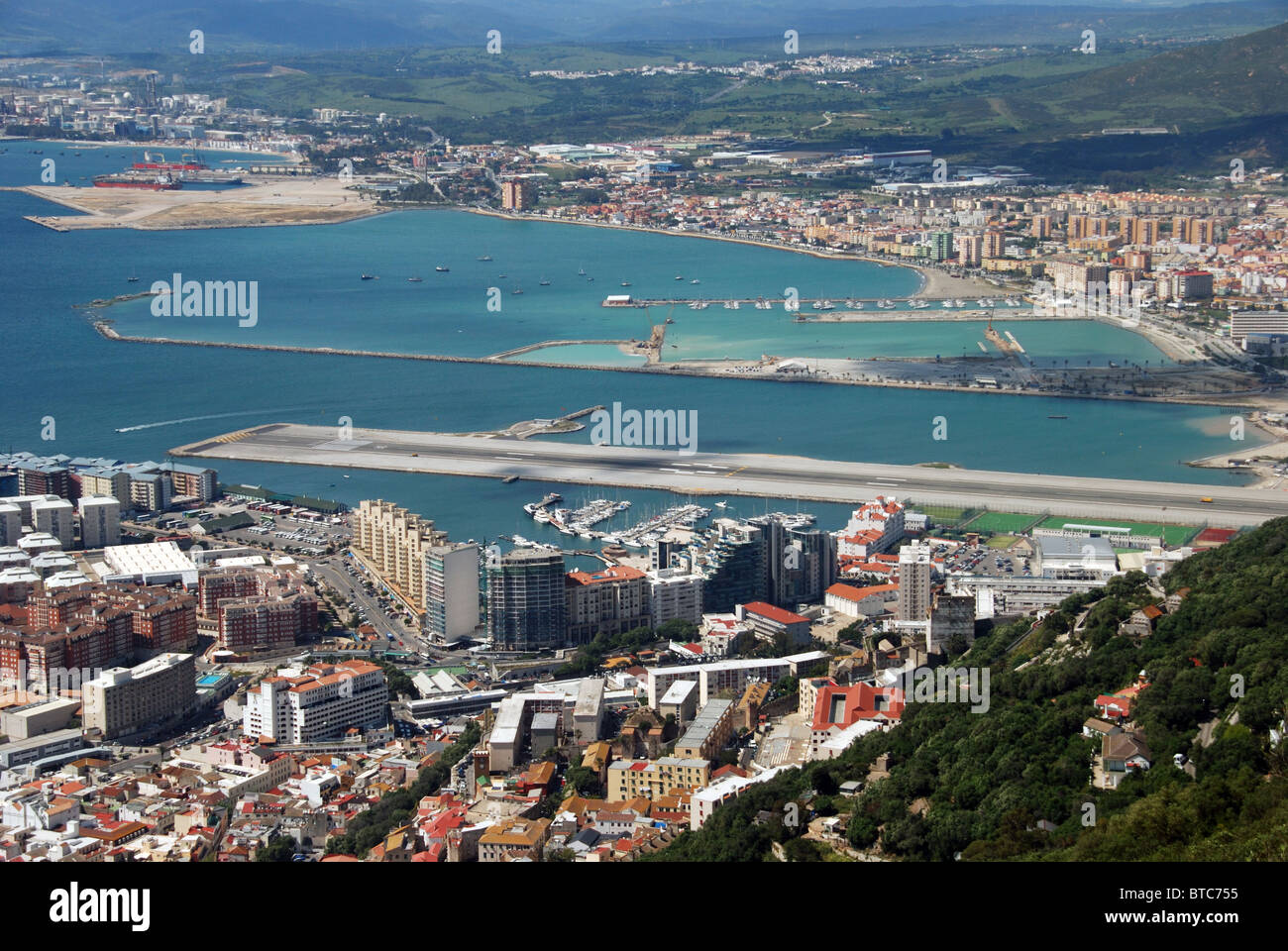 Vista sulla città e l'aeroporto pista dalla stazione della funivia con coste spagnole verso la parte posteriore, Gibilterra, Regno Unito, Europa occidentale. Foto Stock