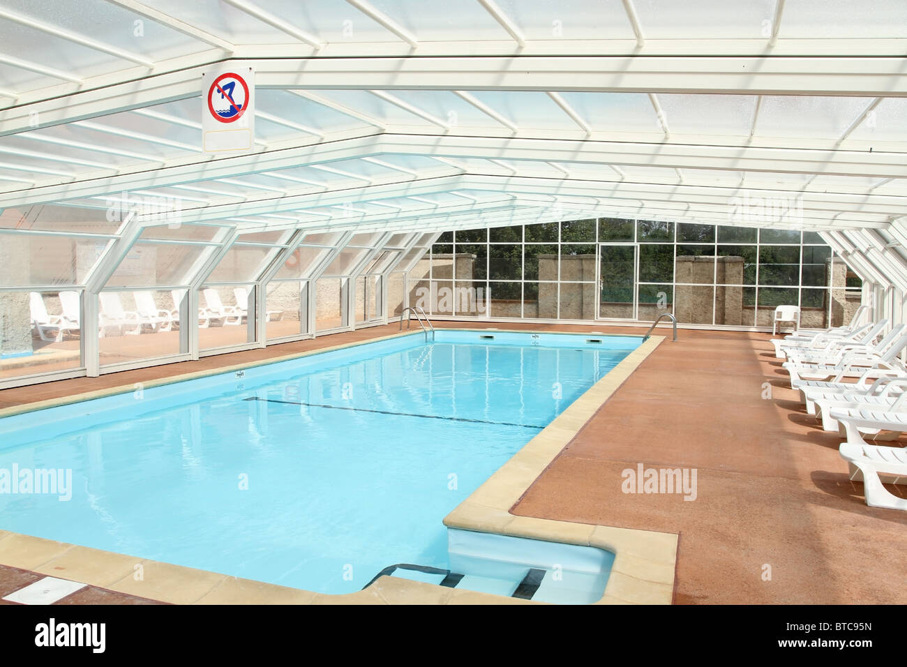 Piscina all'aperto interno alloggiato sotto la copertura di un tetto apribile a scomparsa Foto Stock