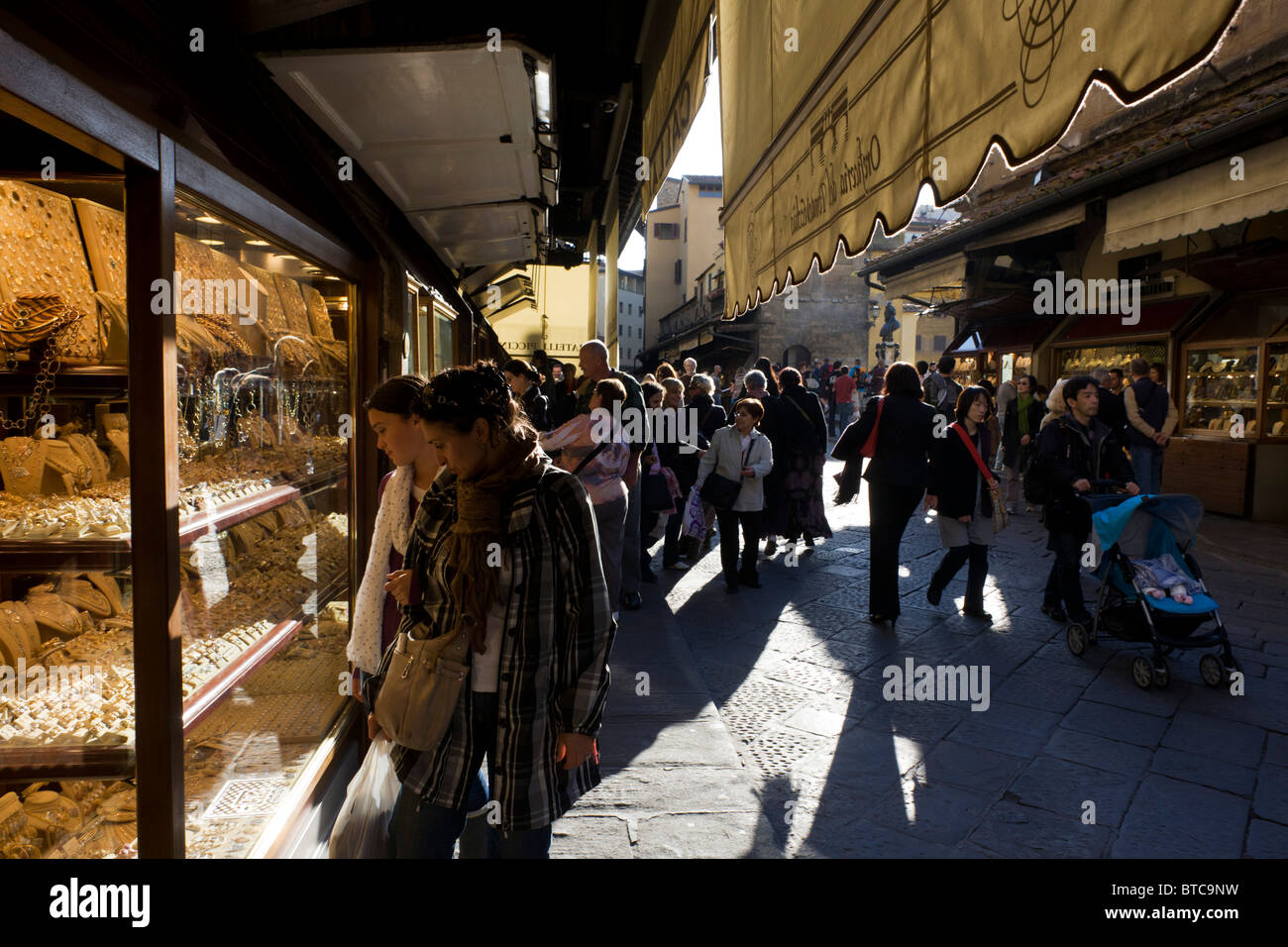 Shoppers navigare molte gioiellerie visualizza su Firenze Ponte Vecchio. Foto Stock