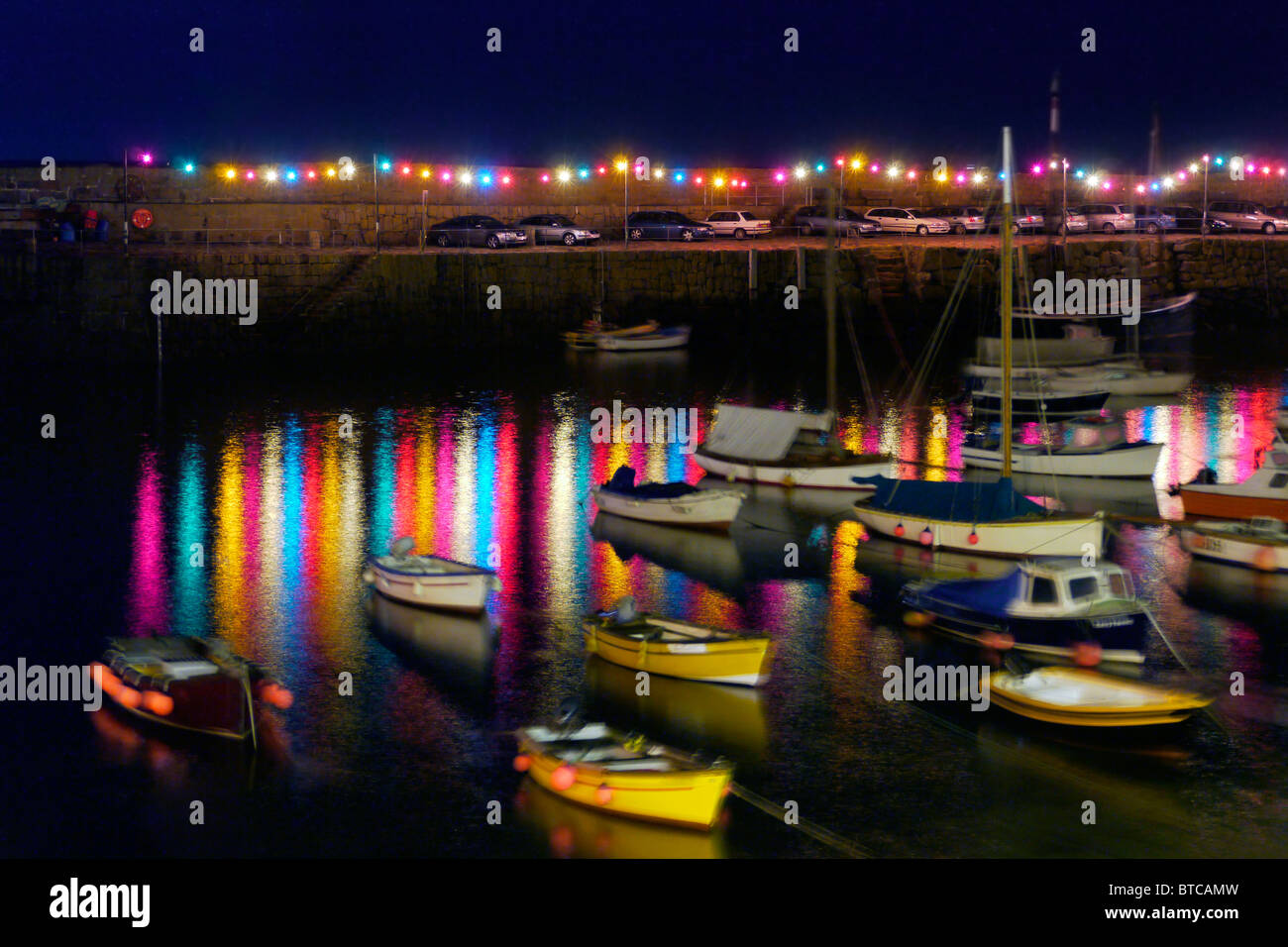 Night Shot di Mousehole, Cornwall Harbour Lights. Una piccola quantità di rumore e la sfocatura dovuta alla lunga esposizione necessaria. Foto Stock