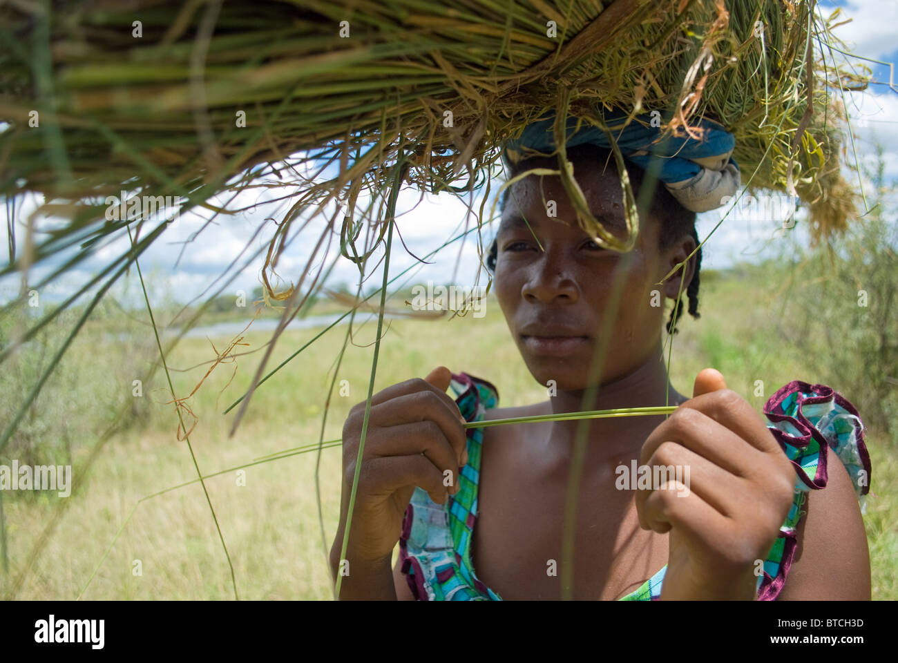 La donna che porta il taglio di erba in Zambia. Foto Stock
