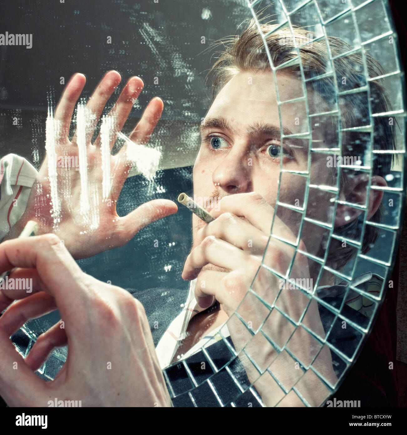 La riflessione di un uomo di inalazione di polvere di cocaina su uno specchio Foto Stock