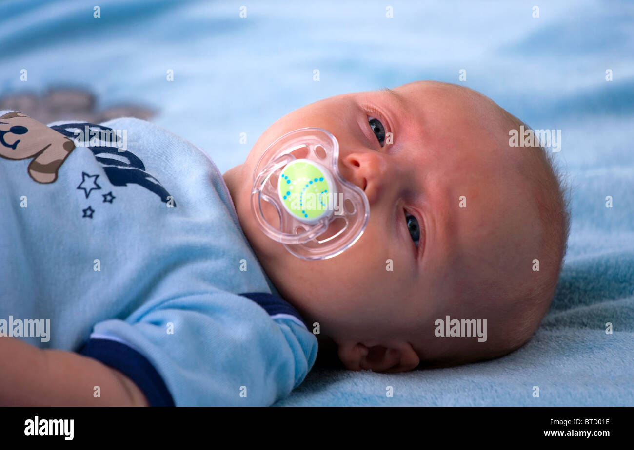 Bambino con succhietto giacente sulla coperta. Foto Stock