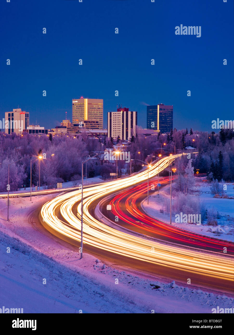 Twilight vista del traffico su Minnesota Blvd. con centro di Anchorage in background, centromeridionale Alaska, inverno Foto Stock