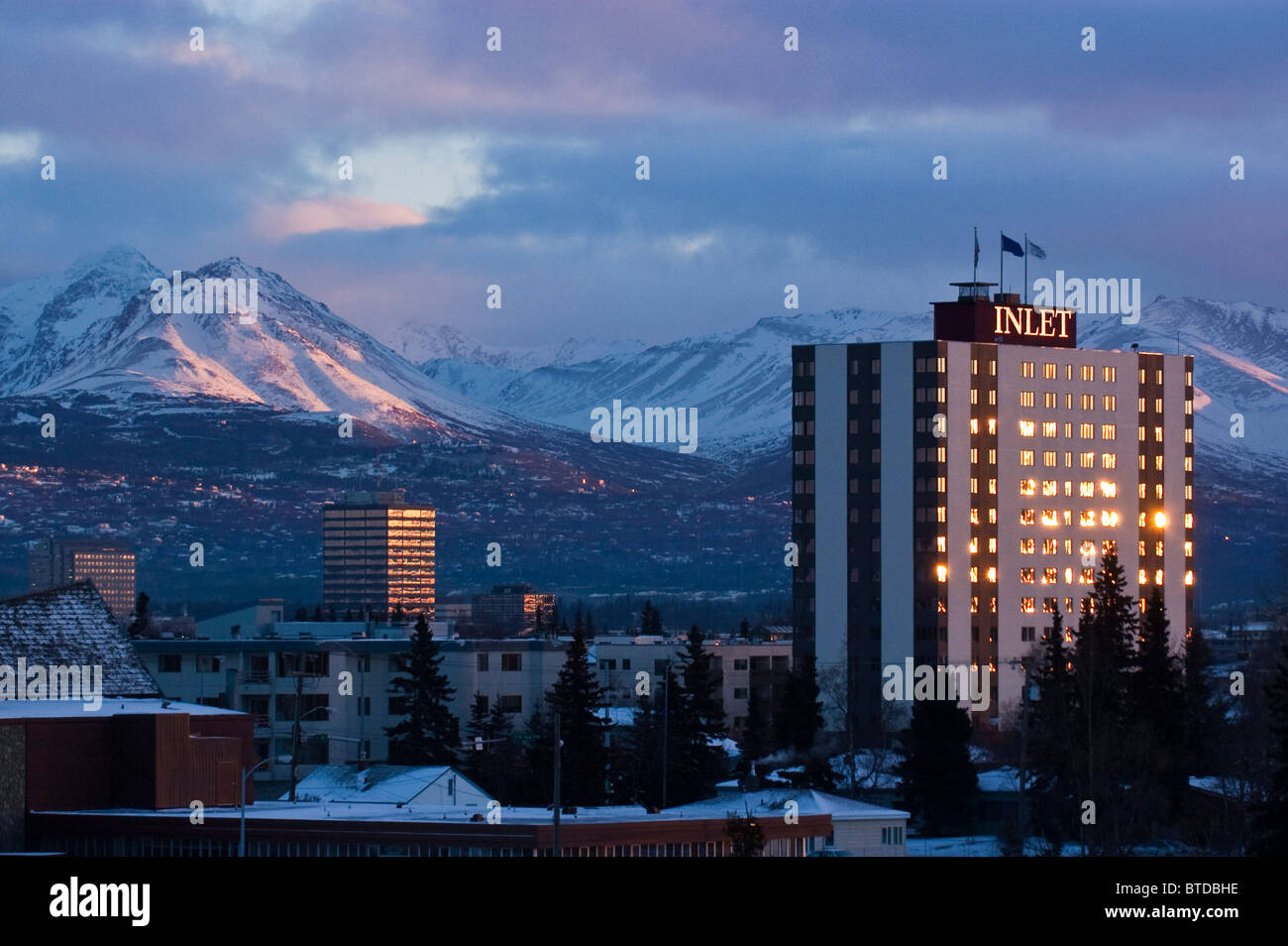 Vista delle torri di ingresso hotel e il centro cittadino di Anchorage con il Chugach Mountains in background, centromeridionale Alaska, inverno/n Foto Stock