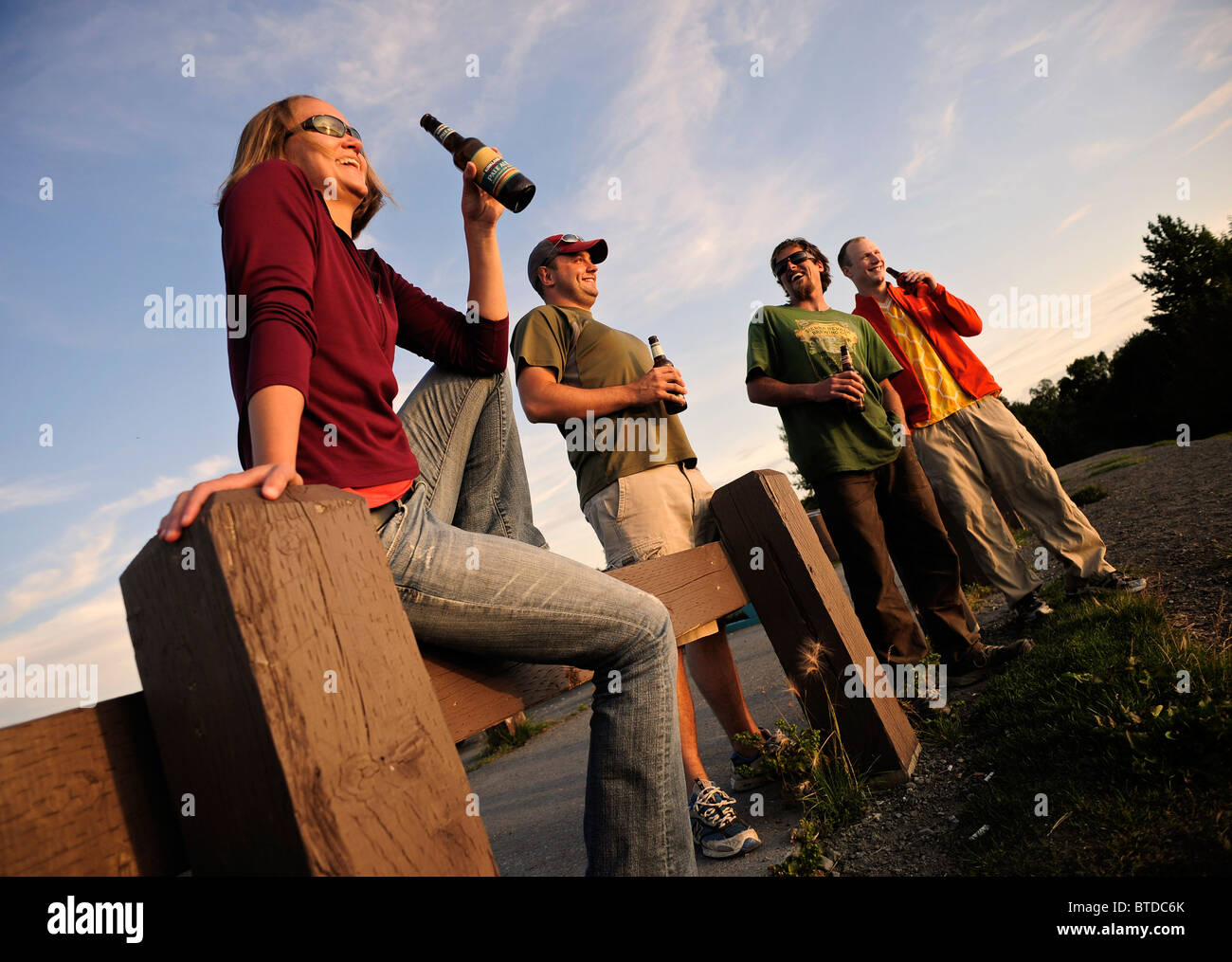 Gruppo di amici appendere fuori e guardare il tramonto al punto Woronzof ad Anchorage, centromeridionale Alaska Foto Stock