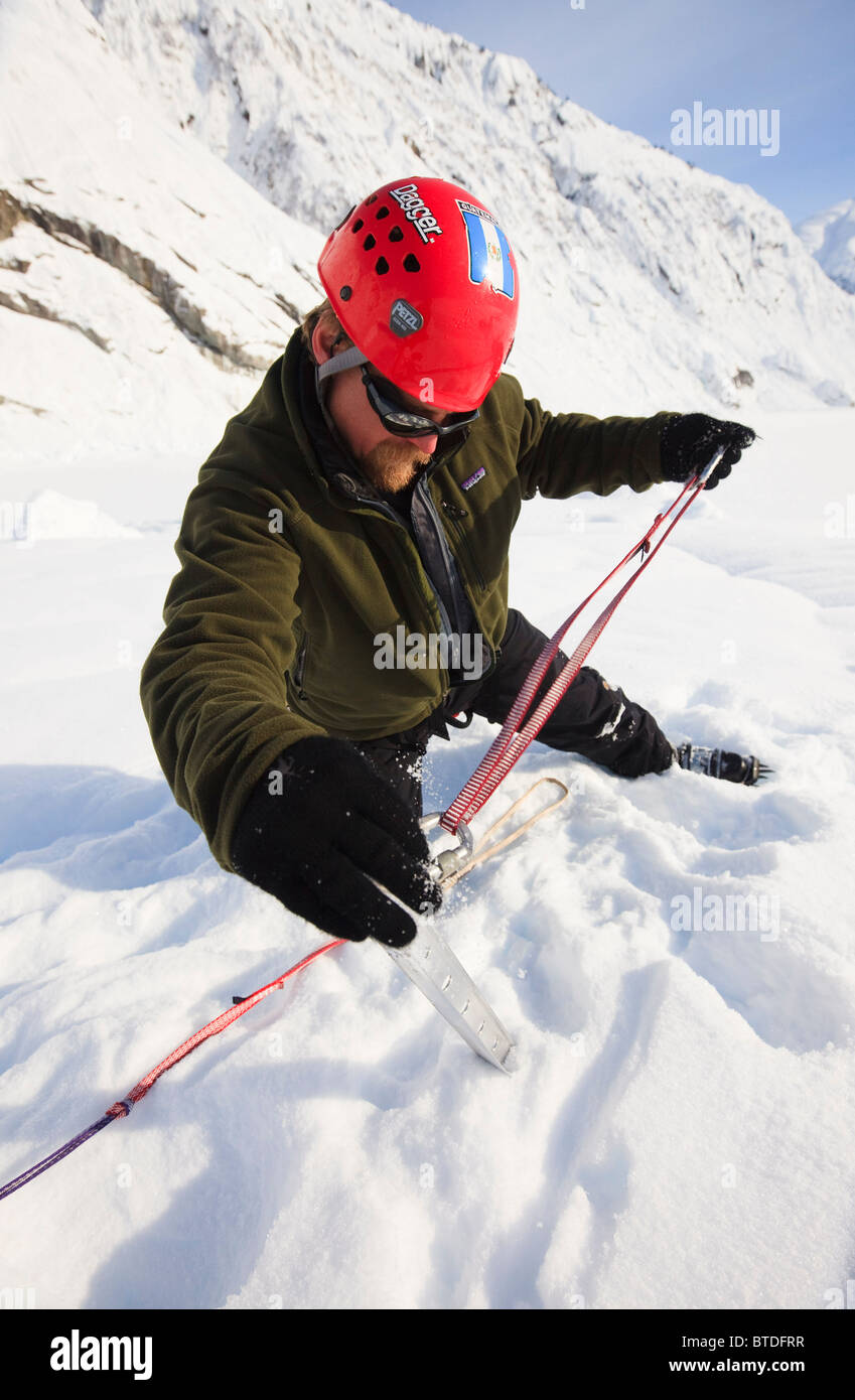 Scalatore imposta un picchetto di neve per la protezione mentre sulla parte superiore del ghiacciaio scuote, Stikine-LeConte deserto, a sud-est di Alaska Foto Stock