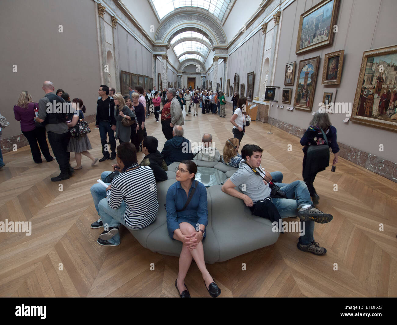Interno del corridoio pieno di turisti nel museo del Louvre a Parigi Francia Foto Stock