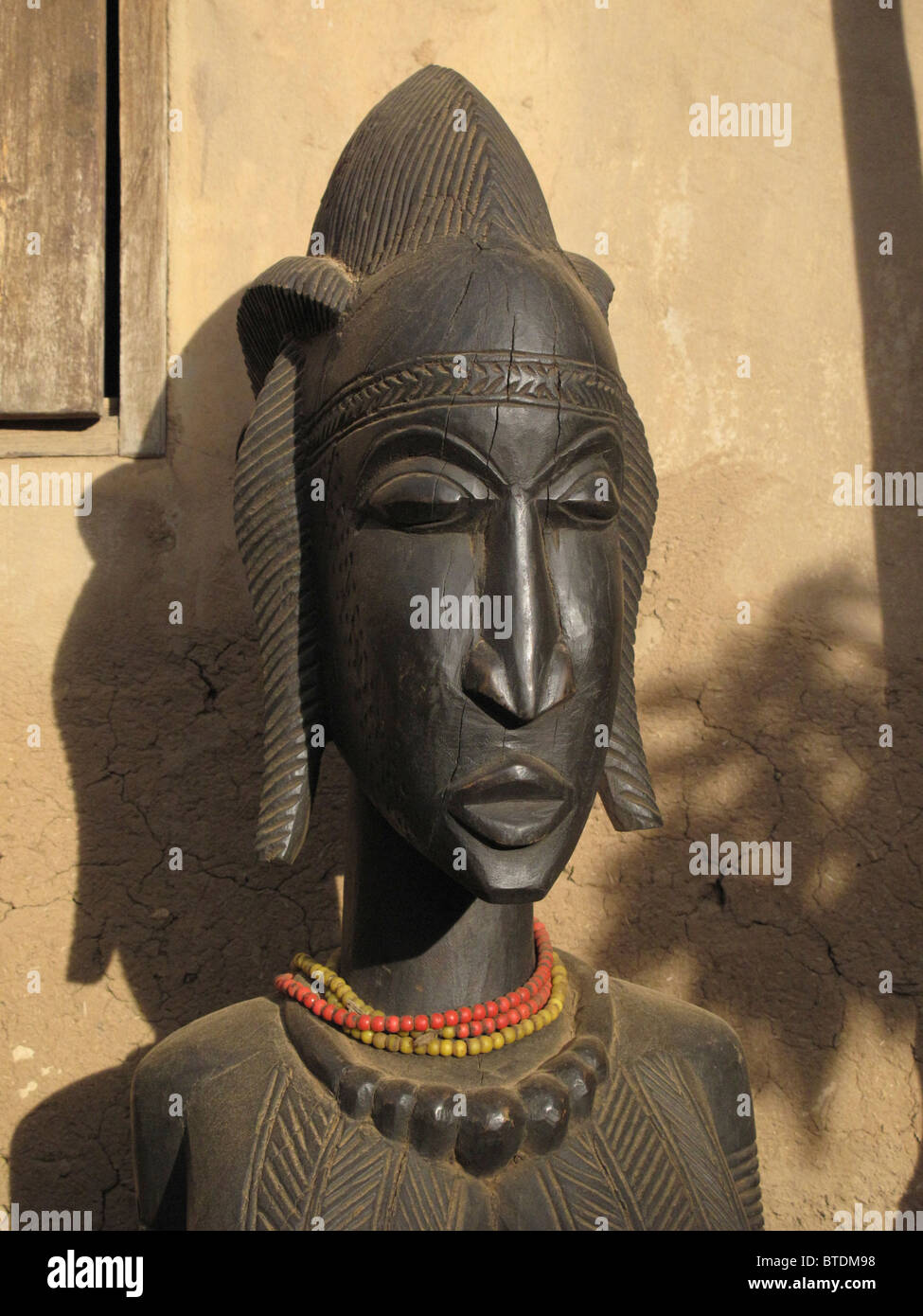 Una scultura in legno del volto di una donna Foto Stock