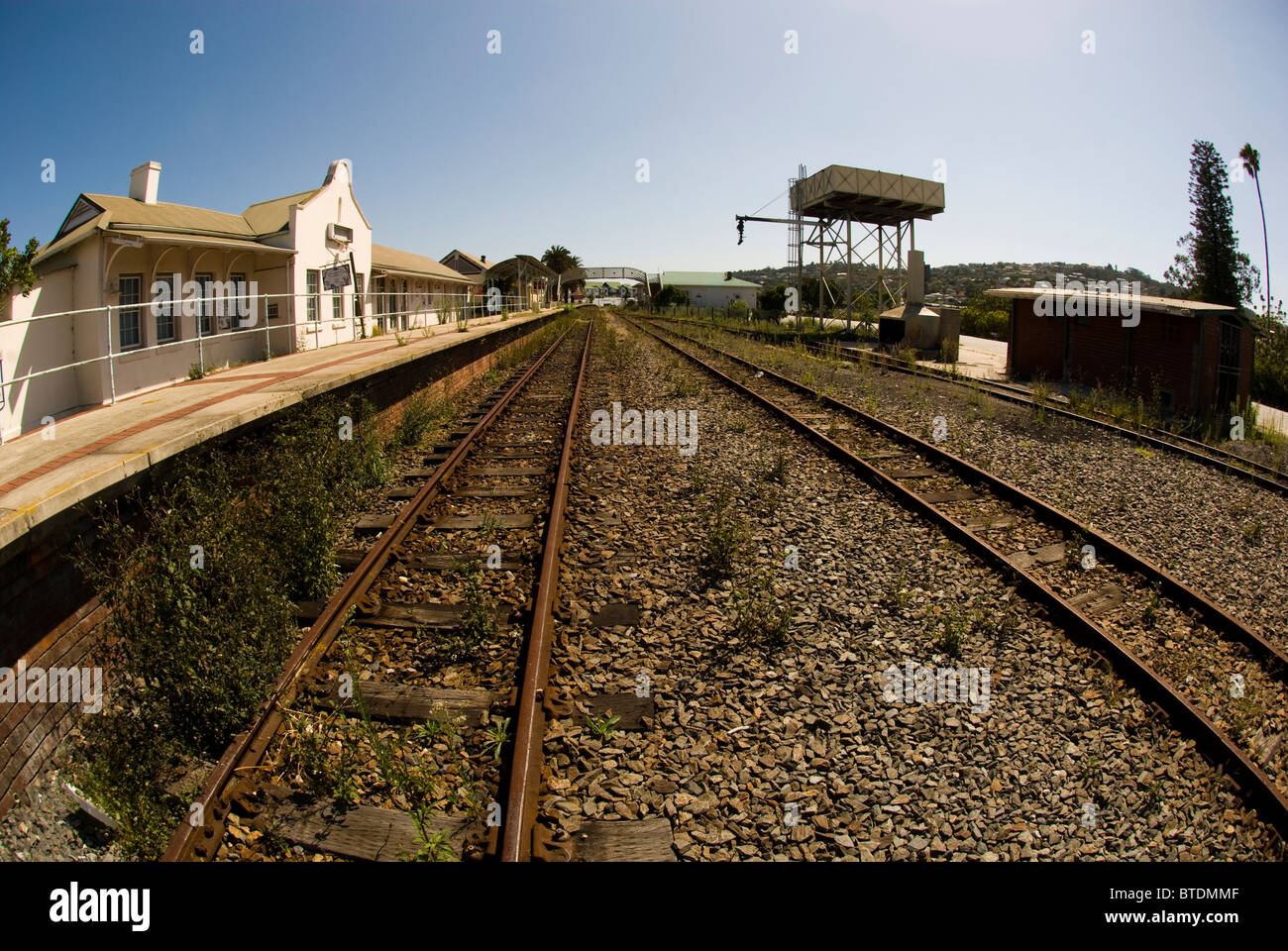 Fish-eye di binari ferroviari in esecuzione passato storico Knysna stazione ferroviaria edificio Foto Stock