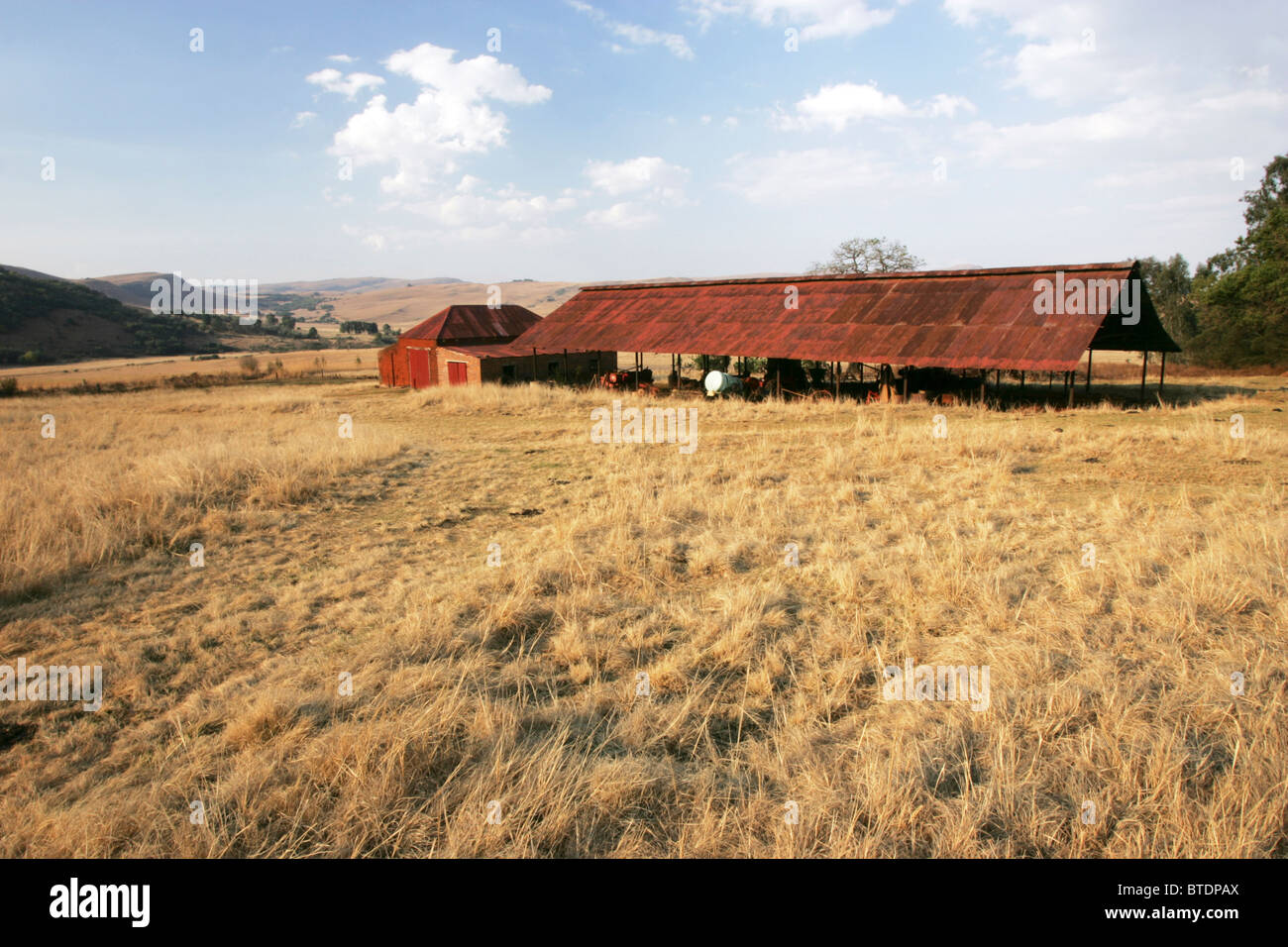 Una vecchia fattoria capannone con un rosso tetto ondulato Foto Stock