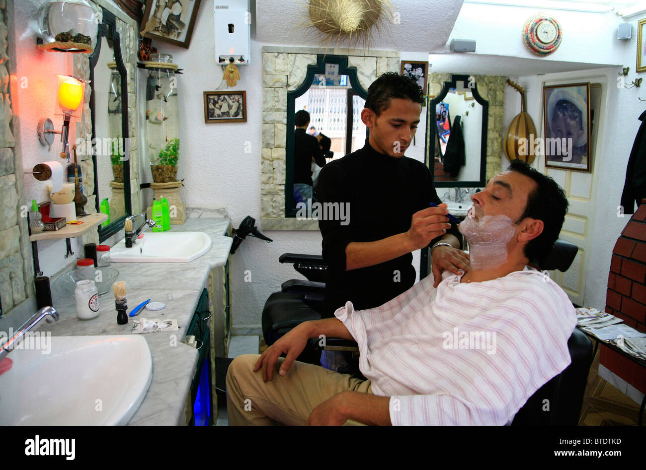 Rasatura barbiere di un cliente Foto Stock