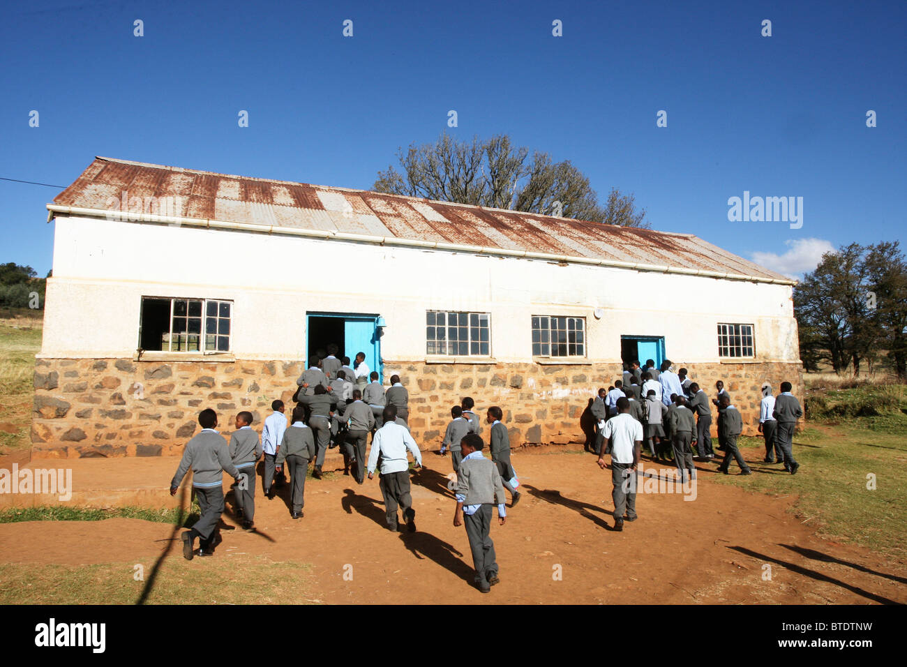Gli alunni a piedi la loro classe che è un Barn convertito in un territorio rurale Kwazulu Natal a scuola Foto Stock