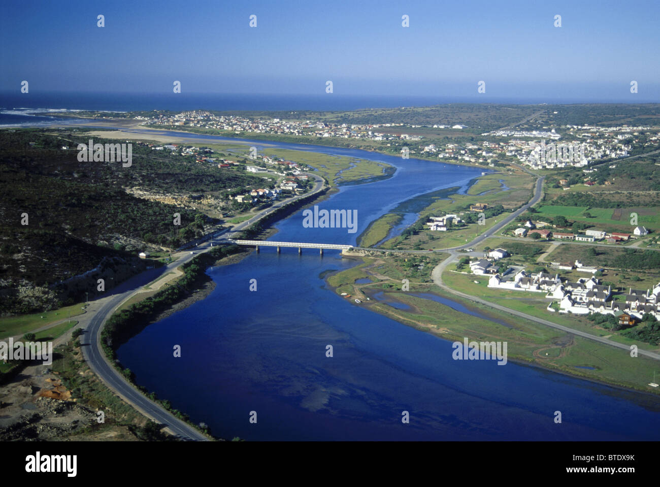 Vista aerea del Stilbaai mostra un grande estuario costiere con un ponte e le case sparse Foto Stock