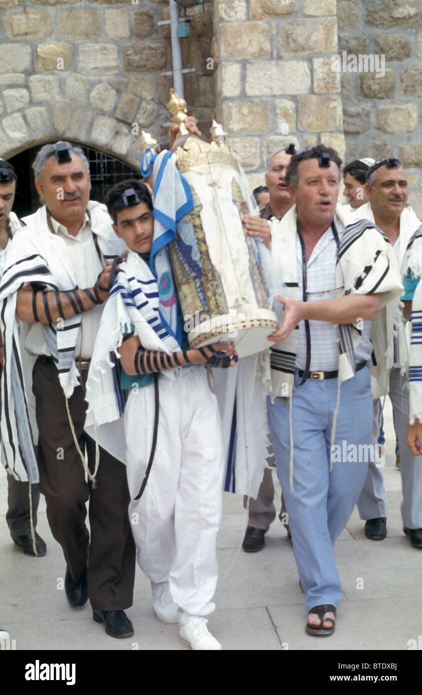 574. Un ragazzo BARMITZVAH, circondato dalla sua famiglia e amici, porta la Torah scorrimento come parte della cerimonia dalla parete occidentale Foto Stock