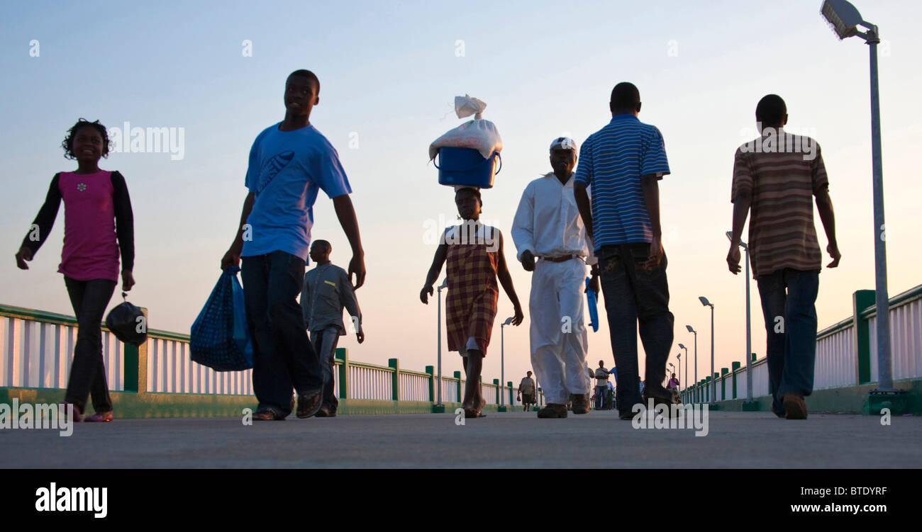La popolazione locale il trasporto del bagaglio e a piedi lungo il molo Inhambane Foto Stock