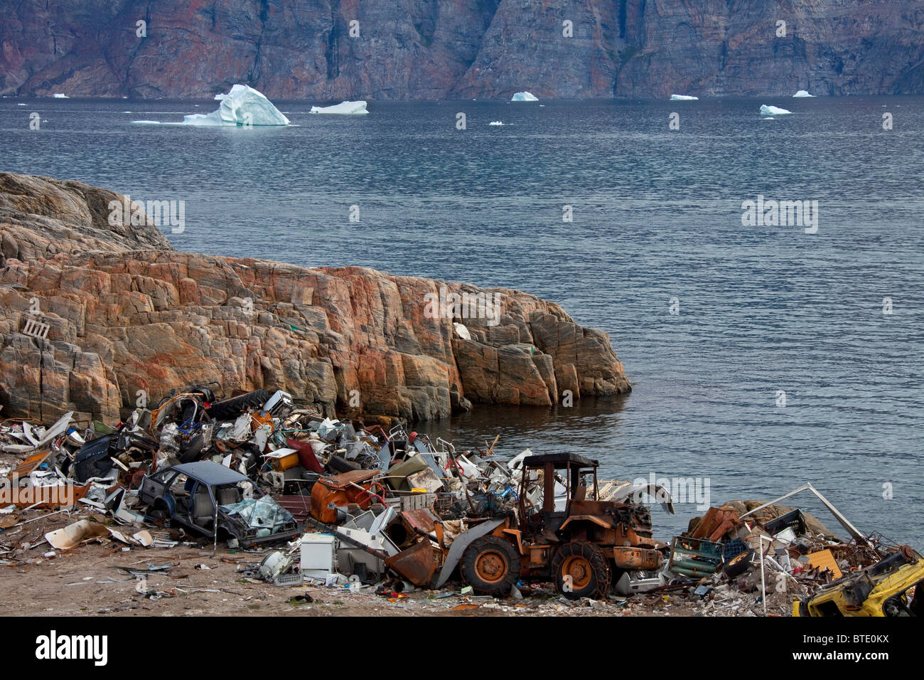 Rifiuti in discarica di rifiuti e Iceberg presso il villaggio di pescatori di Uummannaq, Groenlandia Foto Stock