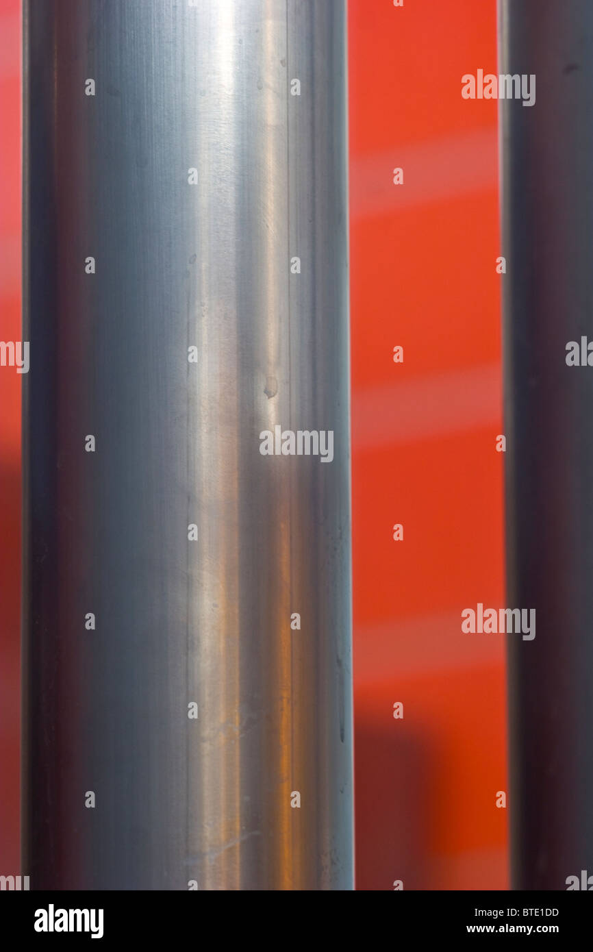 Tubo di acciaio inox su sfondo rosso Foto Stock