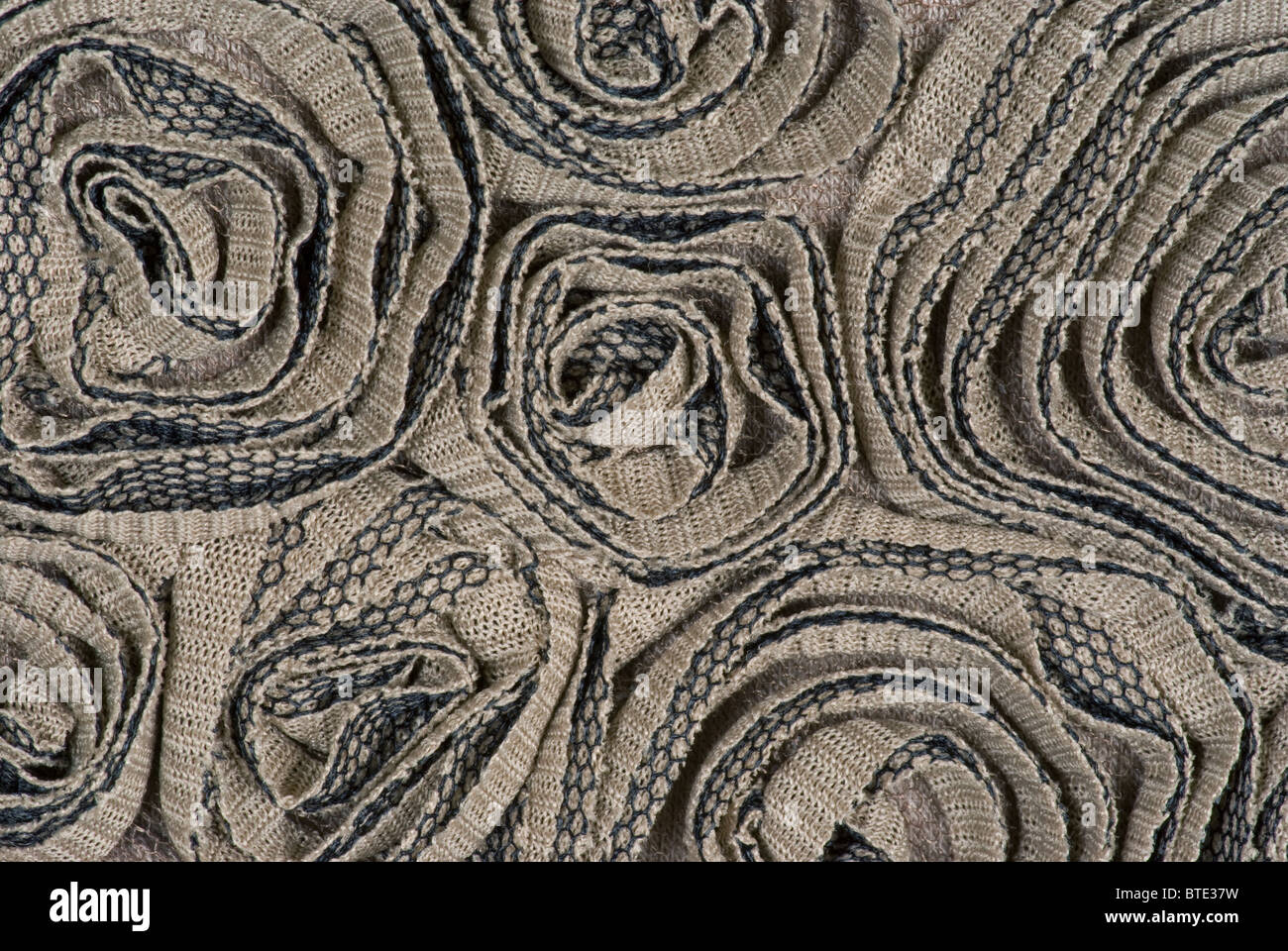 Scultura in tessuto. Tessuto scolpito a maglia in poliestere di cotone in rosette rotonde. Foto Stock