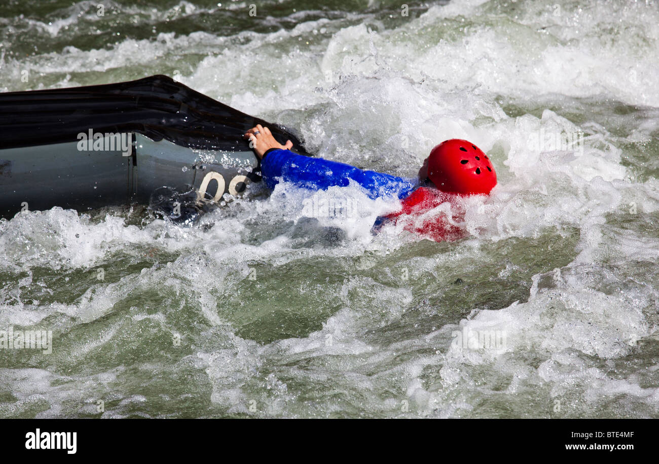 Canoa in acqua bianca in rapide sul fiume con la canoeist cadere al di fuori della sua barca Foto Stock