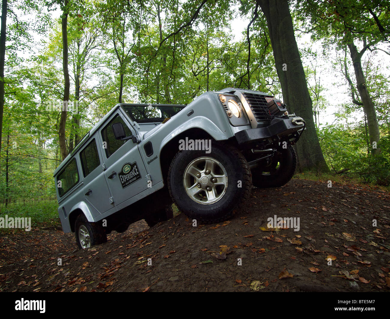 Argento Land Rover Defender la guida su una ripida e scivolosa hill Domaine d'Arthey, Belgio Foto Stock