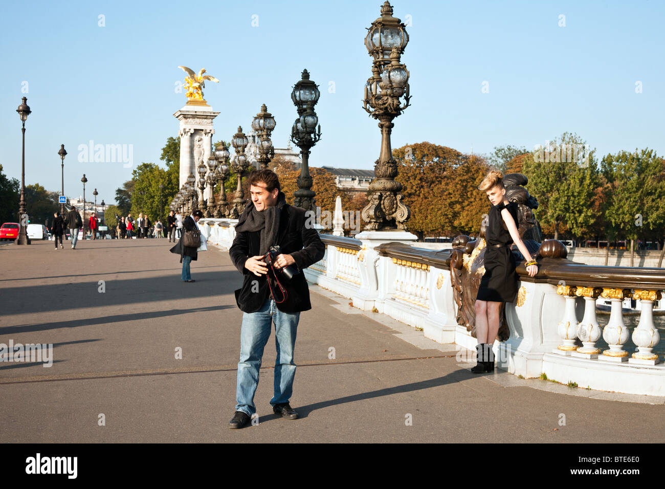 E fotografo di moda di lavoro modello nella vasta impostazione ornati di Pont Alexandre III su una bella giornata d'autunno a Parigi Foto Stock