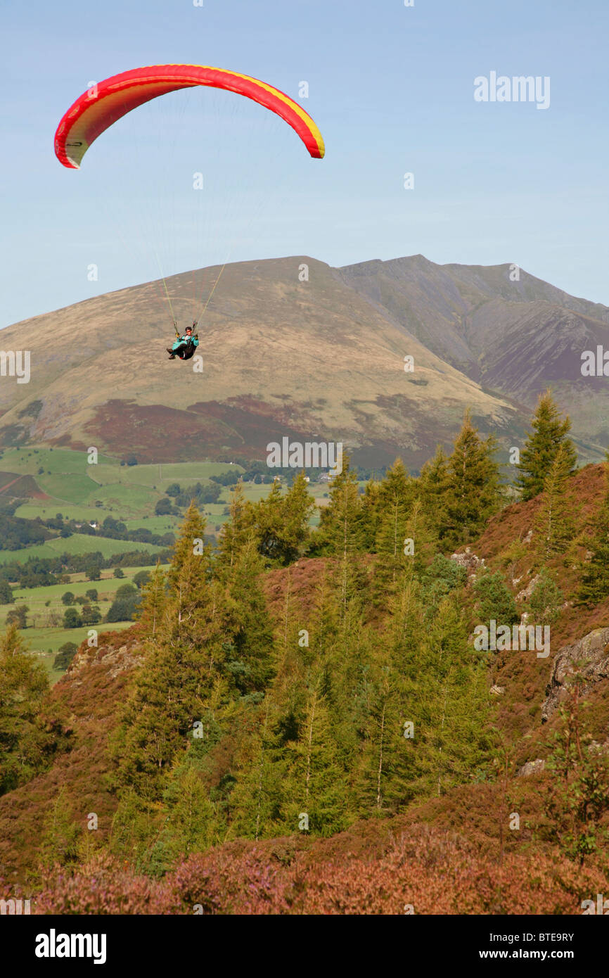 Parasailer volare al di sopra Walla falesia vicino a Keswick, Lake District, Cumbria, Regno Unito, con Skiddaw in background. Foto Stock